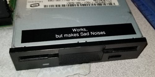 An optical drive with a label on it that says "Works, but makes Sad Noises"